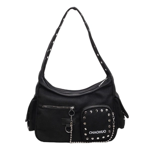 Black canvas crossbody bag with silver rivets and metal chain detail in modern street style