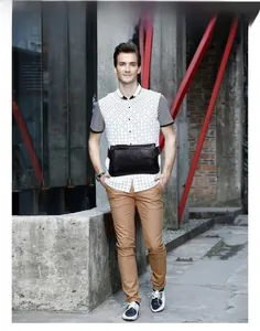 Close-up of black litchi grain leather chest bag with metal zipper on a male model