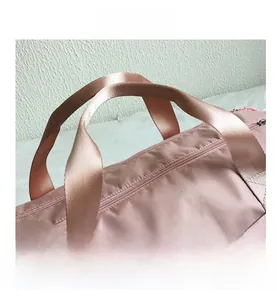 Detail of pink waterproof oxford travel bag showing reinforced stitching and metal zipper
