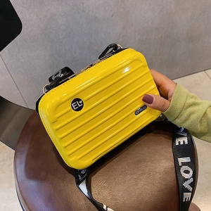 Mini suitcase-style crossbody bag in bright yellow with a stylish wide letter strap