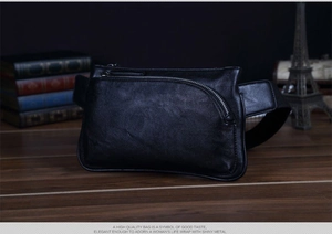 Detail of black pebbled leather waist bag with silver zipper and vintage textured aesthetic