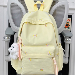 Cute pale yellow canvas backpack with colorful bow embroidery and white plush dog charm