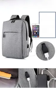 Detail view of grey business backpack showing external USB charging port and internal storage