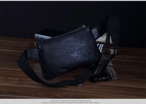 Detail shot of black pebbled leather texture and silver zipper on a vintage chest bag