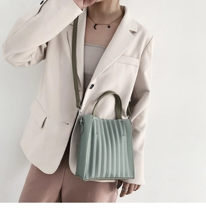 Détail du sac cabas vert clair avec texture plissée et fine bandoulière