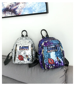 Detailed view of sequin backpack featuring embroidered red lips and LOVE patch detail