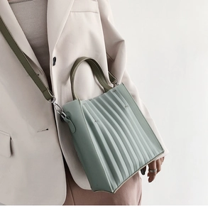 Gros plan d'un sac à main vert clair plissé avec une élégante bandoulière longue réglable
