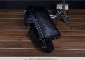Detail shot of black litchi texture leather chest bag with a silver vertical zipper