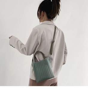 Vue détaillée d'un sac à main plissé vert menthe avec une bandoulière réglable