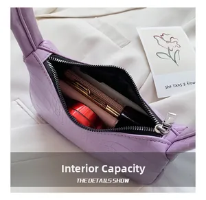 Gros plan de l'intérieur du sac lavande effet crocodile avec rouge à lèvres et portefeuille