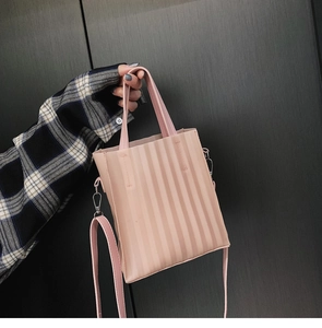 Vue détaillée de la texture à rayures verticales plissées rose clair d'un cabas chic