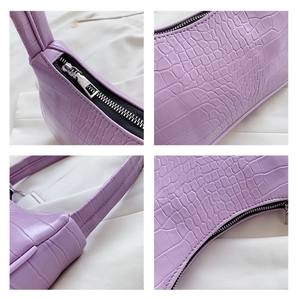 Détails du sac à main violet texture crocodile avec fermeture éclair argentée et cuir
