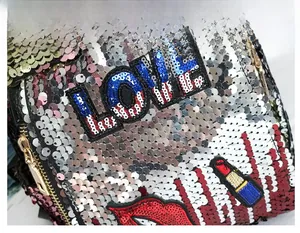Detail of silver sequins with red lips and LOVE embroidery on a stylish backpack