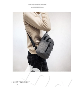 Detail of grey crossbody chest bag with double-zippered main compartments and nylon strap