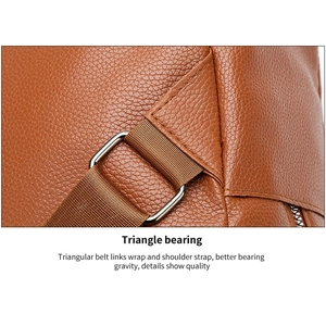 Detail view of reinforced triangular stitching and durable ring on brown leather backpack