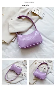 Détail de la texture crocodile violette et du design en demi-lune du sac baguette