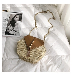 Detail showing hexagonal straw weave texture with brown leather flap and gold metal fringe