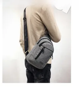Close-up of gray chest bag showing durable oxford fabric and multiple zipper pockets