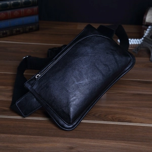 Detailed macro view of black lychee grain leather waist bag with silver metal zippers
