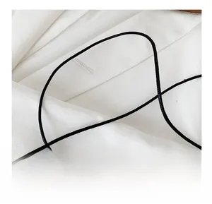 Detailed macro view of a durable black slim shoulder strap on white textured fabric