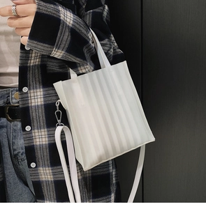 Détail du sac cabas plissé blanc avec texture verticale et bandoulière réglable