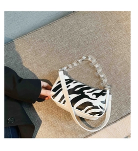 Detailed macro shot of zebra print baguette bag featuring transparent acrylic chain link strap