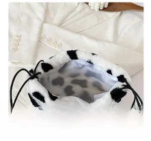 Detail view of the plush cow print bucket bag interior with black drawstring closure