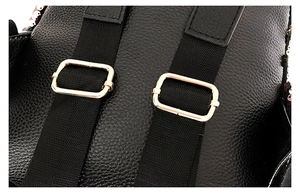 Close-up of black litchi pattern leather straps with golden metal adjustment buckles