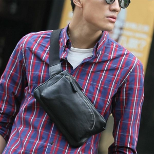 Close-up of stylish black leather chest bag on male model with metal zipper detail