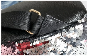 Detail of black lychee leather backpack with red pink sequins and gold metal ring