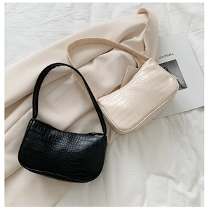 Détails de sacs sous les bras à motif crocodile en noir et beige sur fond élégant