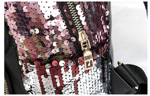 Close-up of pink and red sequins on black lychee leather backpack with golden metal zipper