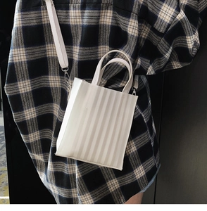 Détail du mini sac cabas blanc avec plis accordéon verticaux et fine bandoulière