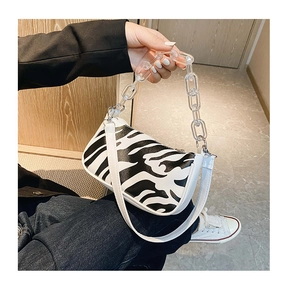 Detail of zebra pattern shoulder bag with white leather strap and acrylic chain link