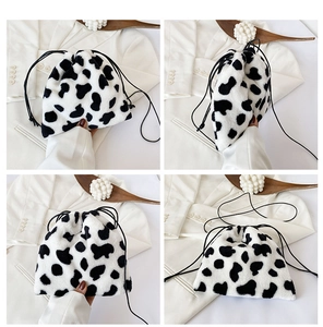 Detail view of plush faux fur drawstring bag featuring stylish cow print texture