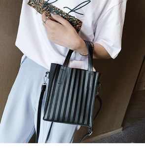Détail d'un sac à main carré plissé noir avec bandoulière réglable porté par un mannequin