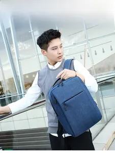 Side view of dark blue business laptop backpack against a modern glass building