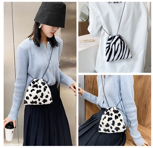 Detailed views of mini plush drawstring shoulder bag with cow and zebra patterns