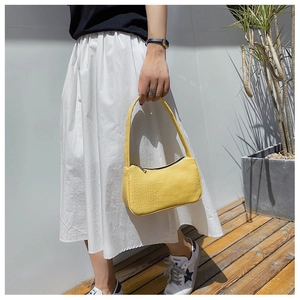 Détail du sac sous le bras en cuir jaune à motif crocodile avec fermeture éclair