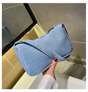 Détail du sac baguette bleu clair avec motif crocodile et fermeture éclair argentée