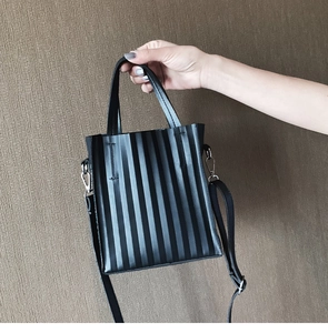 Détail du sac cabas plissé noir avec plis verticaux et bandoulière réglable
