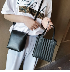 Détail d'un sac bandoulière noir et d'un sac cabas plissé portés par un mannequin