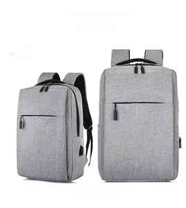 Detail showing the light grey laptop backpack with built-in USB charging port and zipper