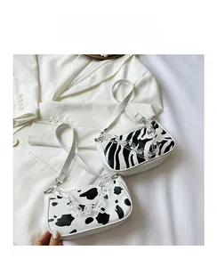 Detailed view of animal print baguette bags with clear acrylic chains on white background