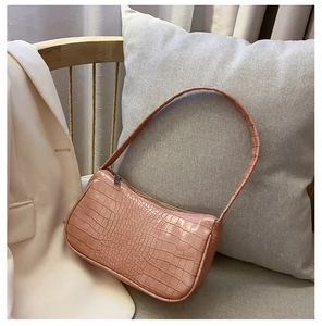 Détail montrant la texture crocodile rose et la structure rectangulaire du sac baguette chic