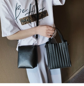 Détail du sac à bandoulière noir minimaliste et du cabas plissé avec garnitures argentées
