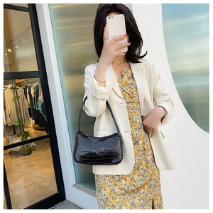 Selfie miroir montrant le sac baguette noir à motif crocodile sur l'épaule