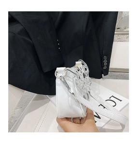 Detail of white baguette bag with thick transparent acrylic chain and slim shoulder strap