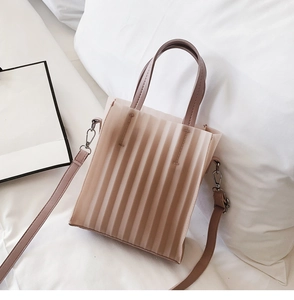 Détail du sac plissé nude montrant la texture translucide et les ferrures argentées