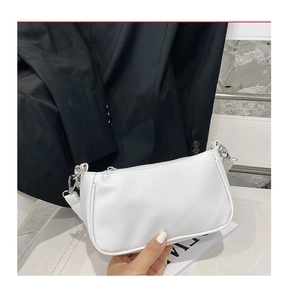 Detail of white cow print baguette bag with silver zipper and leather strap texture